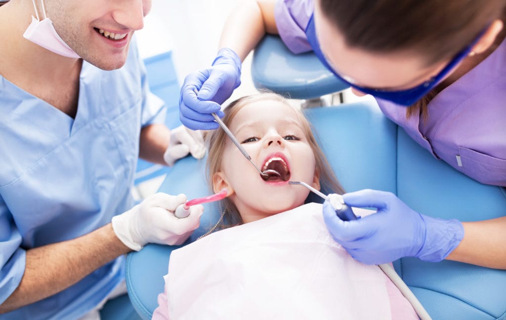 Girl having teeth examined at dentists