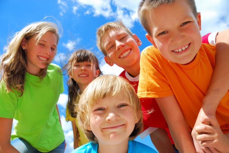 there are many children standing together in a circle on a sunny day
