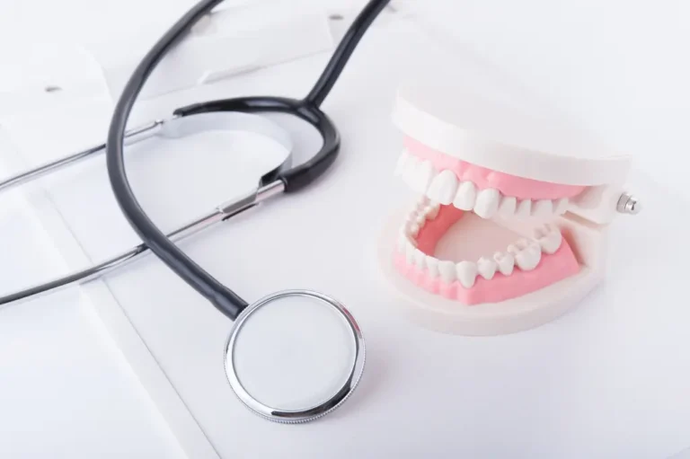 Dentist holding a tablet with the words “Dental Insurance” overlayed, accompanied by tooth and shield icons.